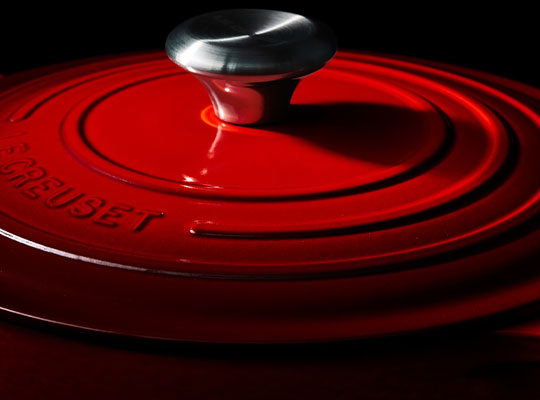 detail of a cerise dutch oven in dramatic lighting